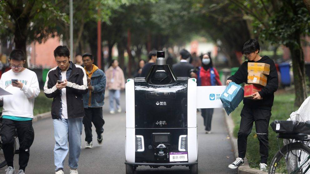 Consumers Pick Up Packages From Delivery Robot “xiaomanlv” On University Campus