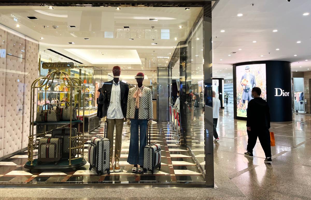 Customers, including tourists, queue at the entrance to the LVMH